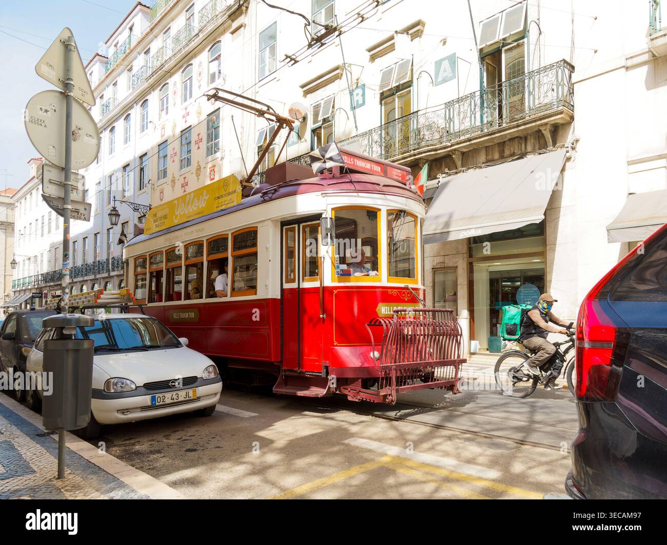 Die historische gelbe Straßenbahn von Lissabon überquert eine Stadtstraße in Lissabon, Portugal, das Symbol des traditionellen öffentlichen Verkehrssystems der Hauptstadt. Stockfoto