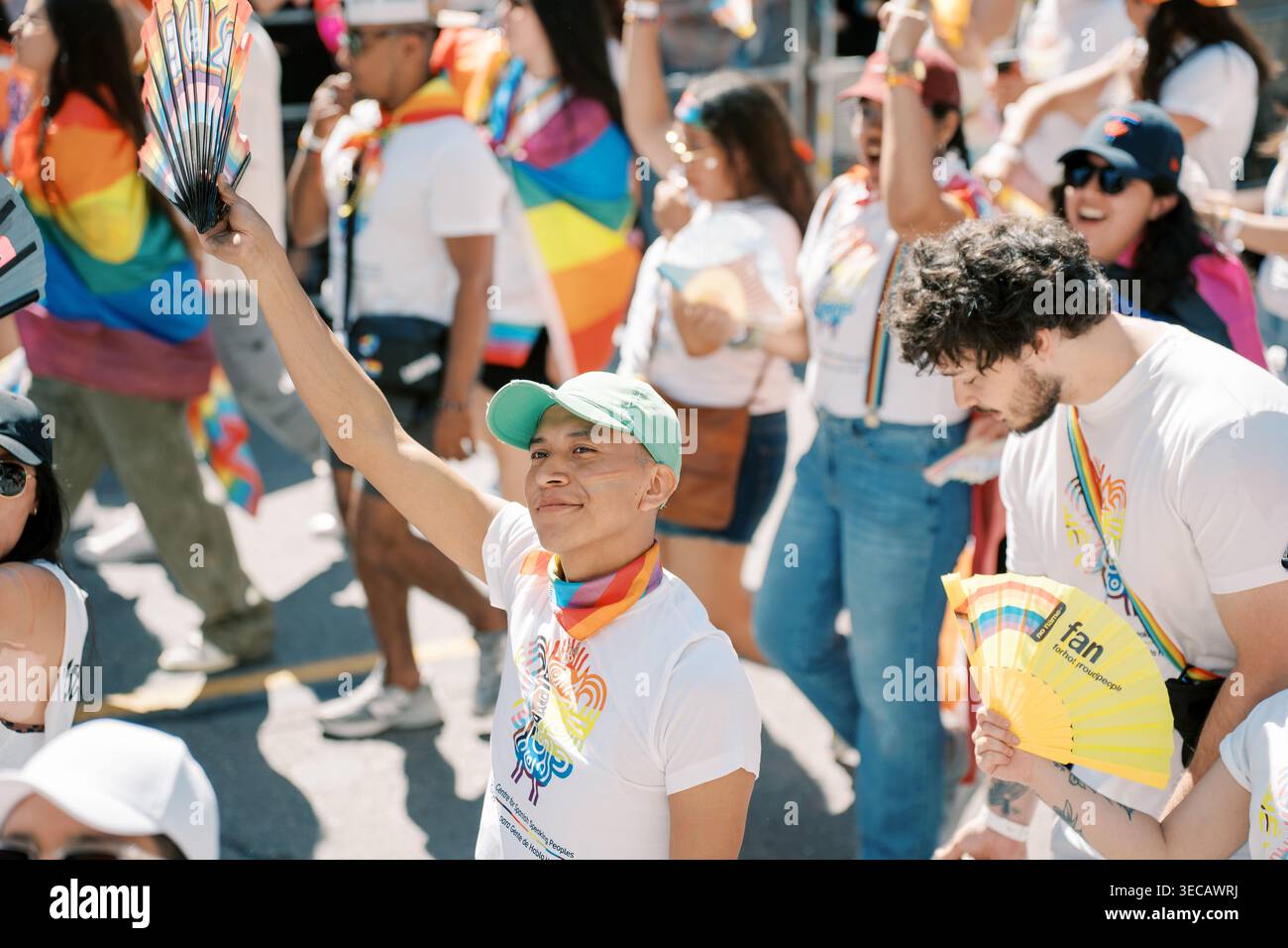 Toronto, Kanada - 29. Juni 2025: Teilnehmer, die mit einem Regenbogenschal die Faust heben Stockfoto