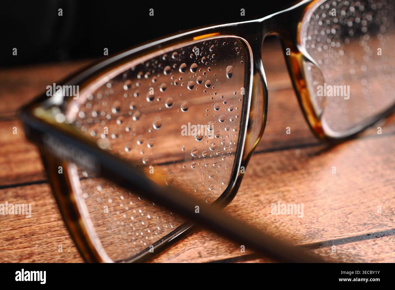 Gläser mit Wassertropfen auf Holzoberfläche Stockfoto