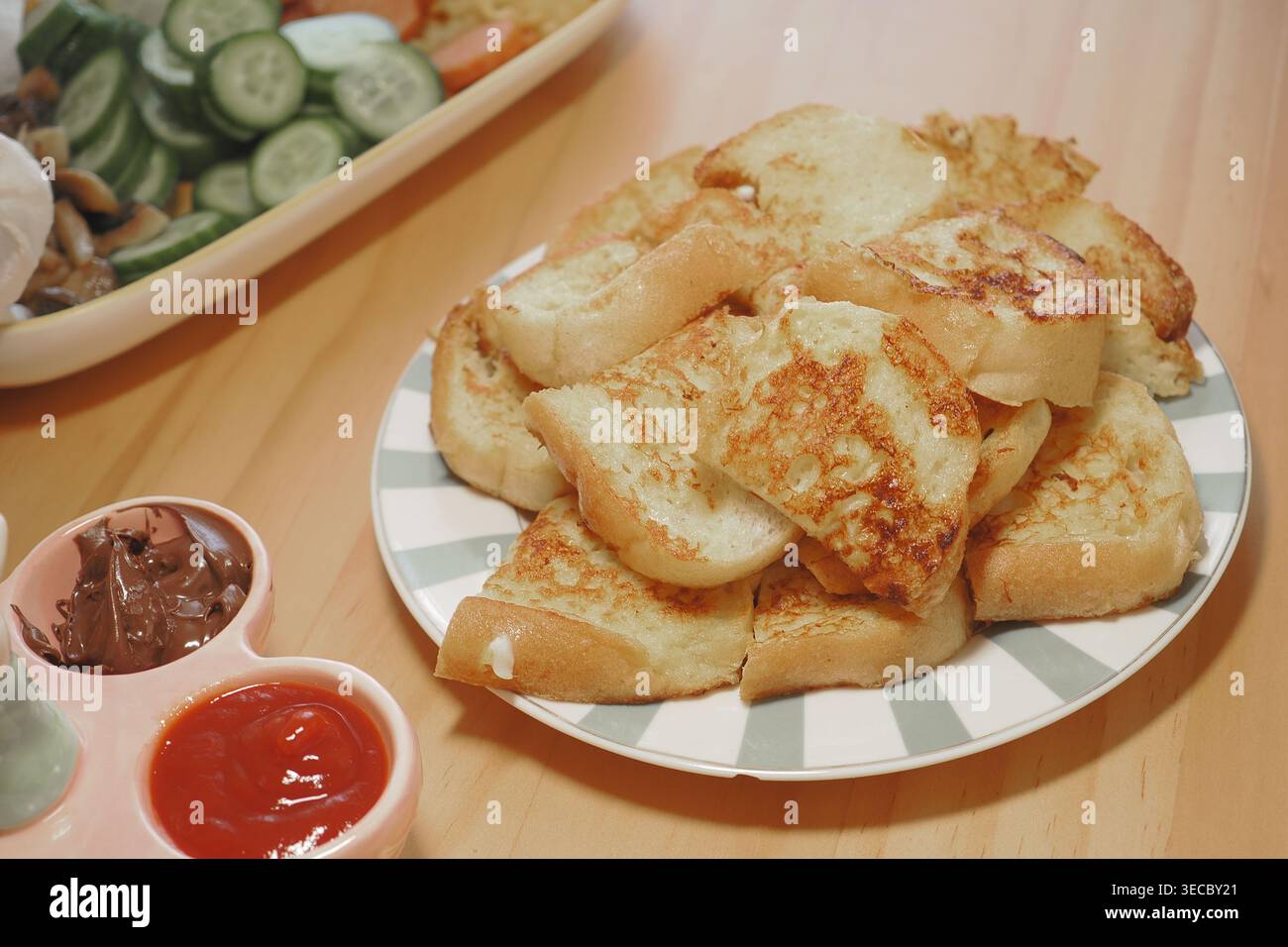 Stapel gerösteter Brotscheiben auf Teller mit Dips und Salat zum Frühstück oder Snack Stockfoto