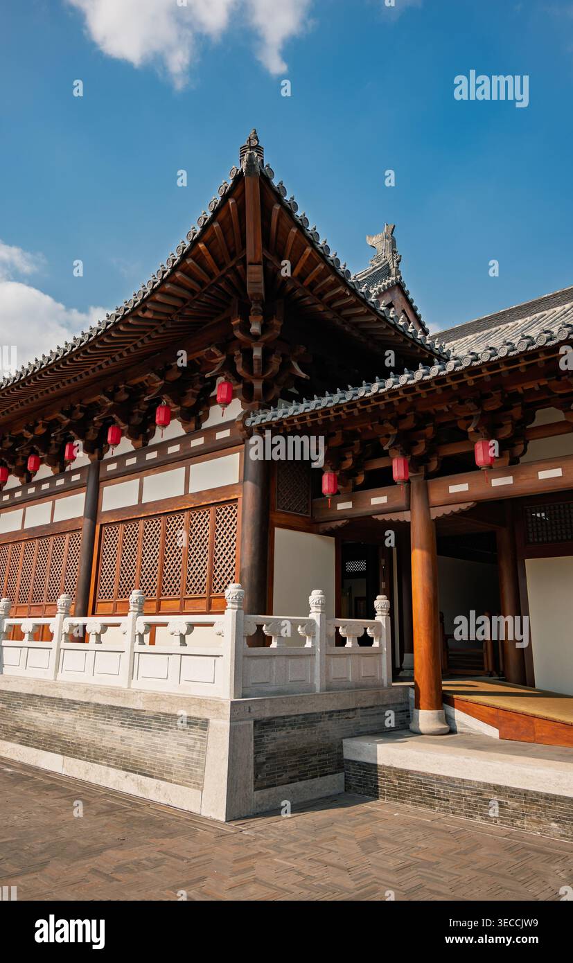 Verziertes traditionelles chinesisches Gebäude mit roten Laternen und einem gestuften Dach, das an einem klaren Tag festgehalten wird Stockfoto