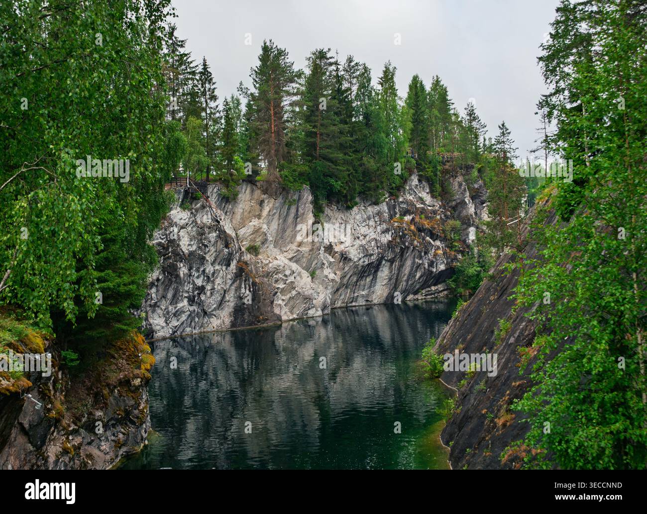 Das tiefe smaragdgrüne Wasser reflektiert steile weiße Marmorklippen und grüne Baumkronen im Ruskeala Mountain Park, Karelien, Russland. Stockfoto