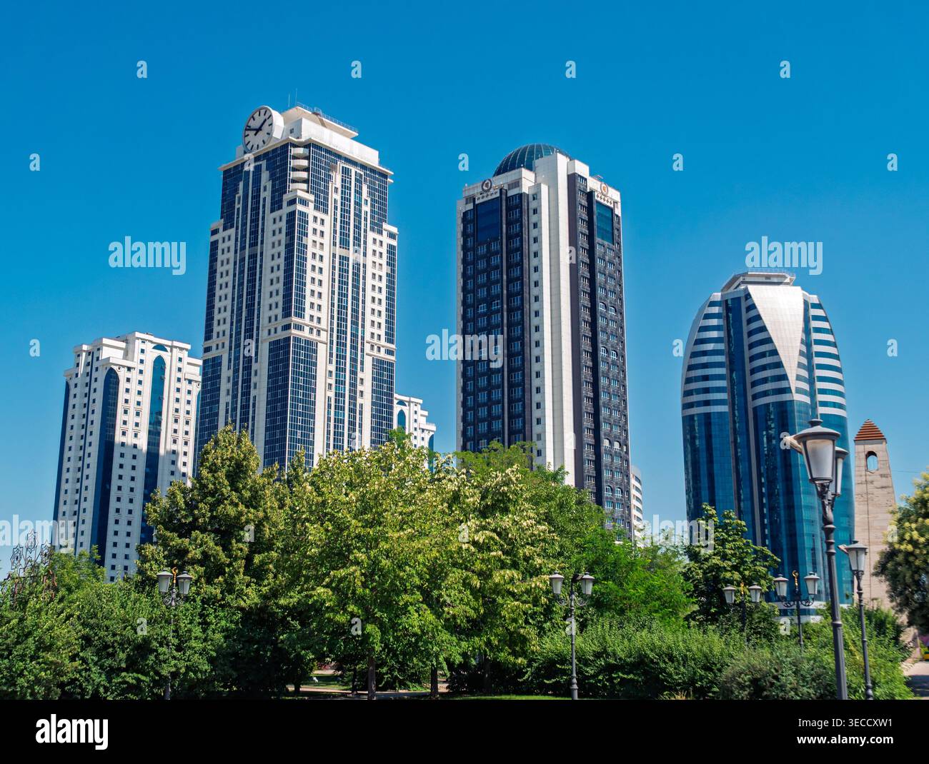 Grosny, Russland - 30. Juli 2021: Stadttürme von Grosny mit modernen Wolkenkratzern und üppig grünen Parkbäumen Stockfoto