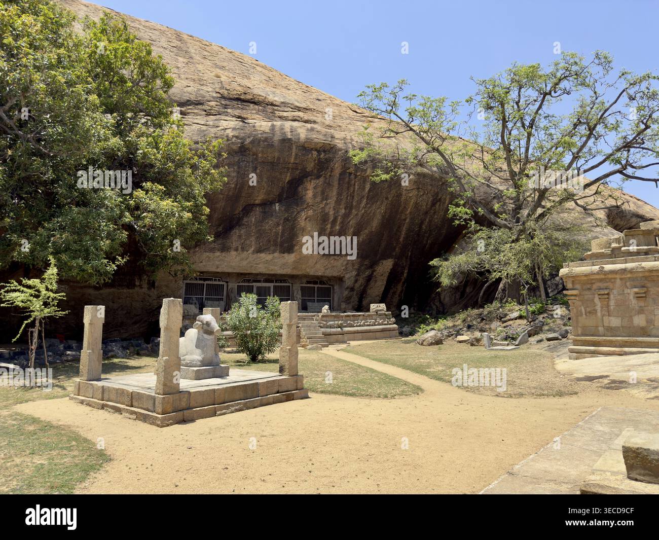 Felsformation mit Tempelkomplex und antiken Skulpturen und Bäumen unter klarem Himmel, Vijayalaya Choleeswaram Tempel, Tamil Nadu, Indien Stockfoto