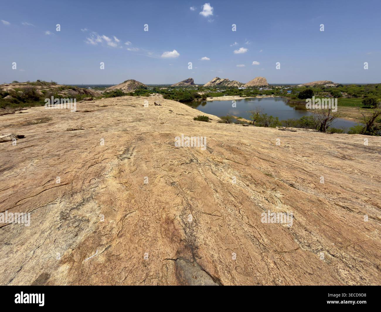 Panoramablick über Felsen in Richtung eines Sees und Hügel unter einem blauen Himmel mit wenigen Wolken, Vijayalaya Choleeswaram Tempel, Tamil Nadu, Indien Stockfoto