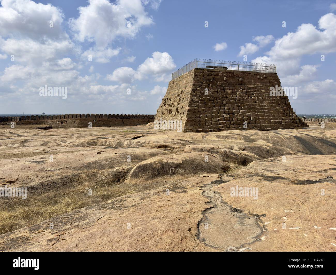 Historische Steinstruktur auf einem breiten felsigen Plateau unter blauem Himmel mit Wolken, Thirumayam Fort, Thirumayam, Tamil Nadu, Indien Stockfoto