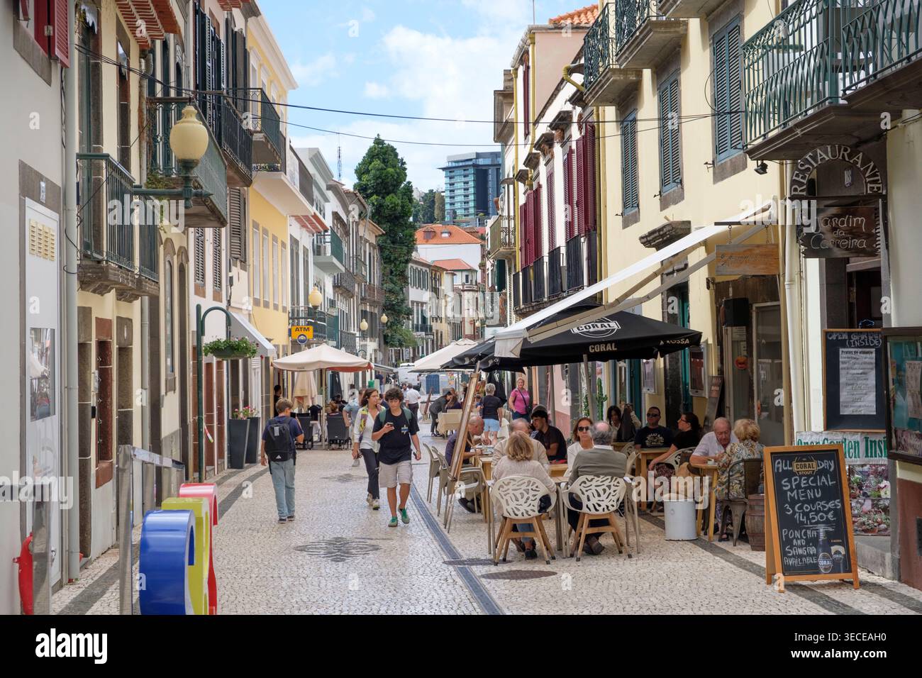 Eine geschäftige Straße in Funchal mit Restaurants und Touristen Stockfoto