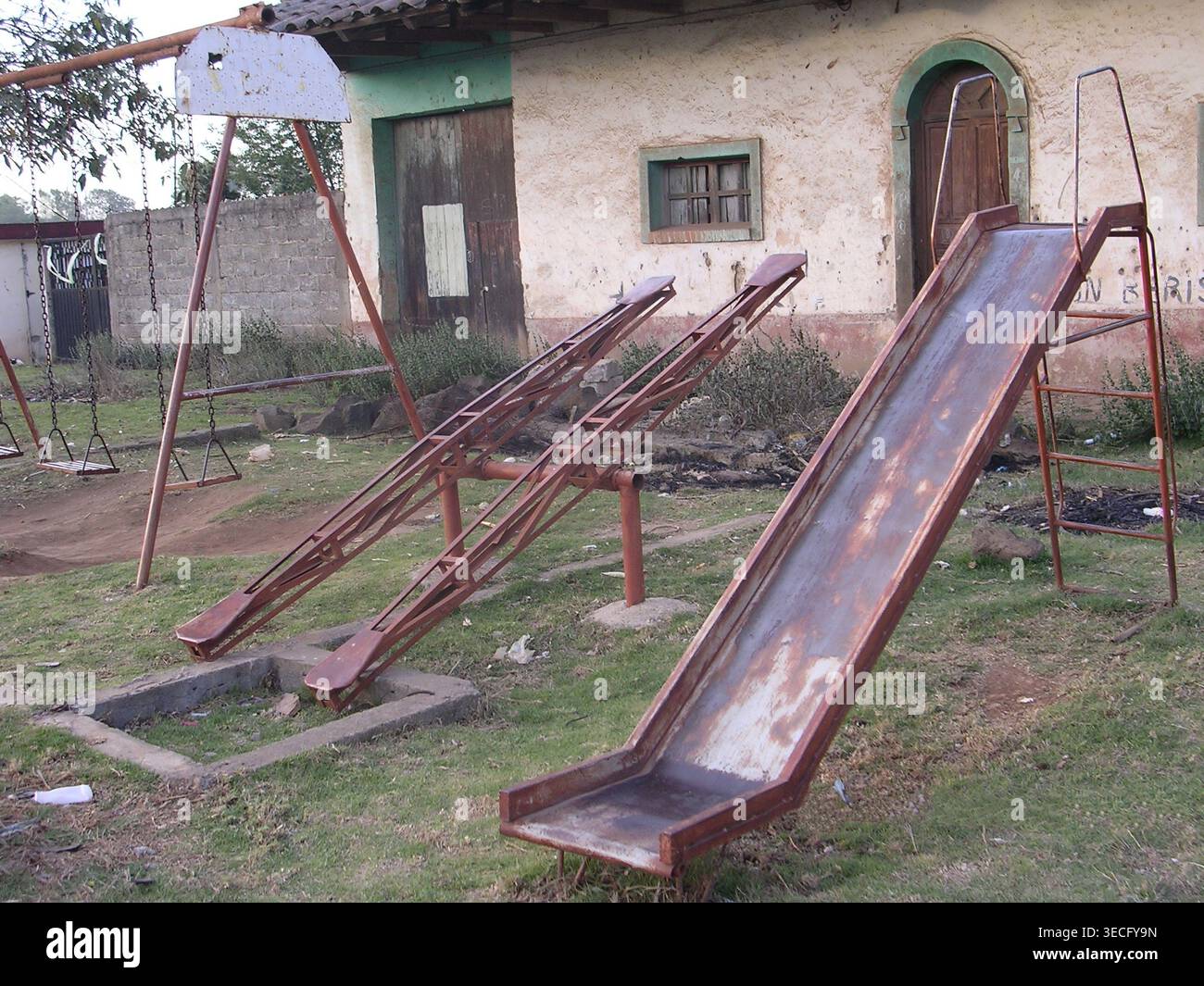 Rustikale Metallrutschen und Schaukeln in einem ländlichen mexikanischen Dorf Stockfoto