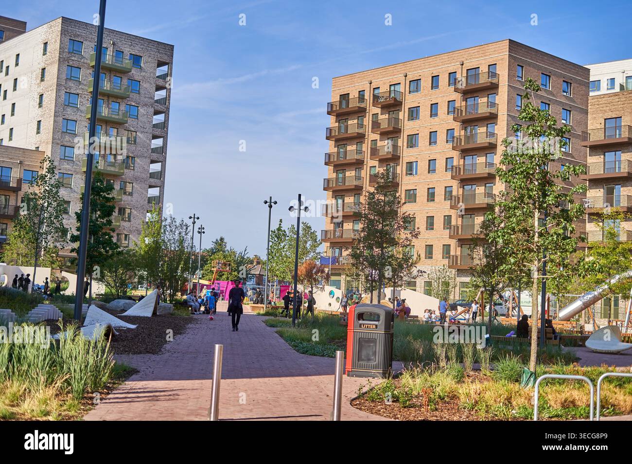 Moderne mehrstöckige Wohnapartmenthäuser mit Ziegel- und Steinverkleidungen, die Balkone aufweisen, um einen gemeinsamen Stadtpark und Kinderspielplätze herum Stockfoto