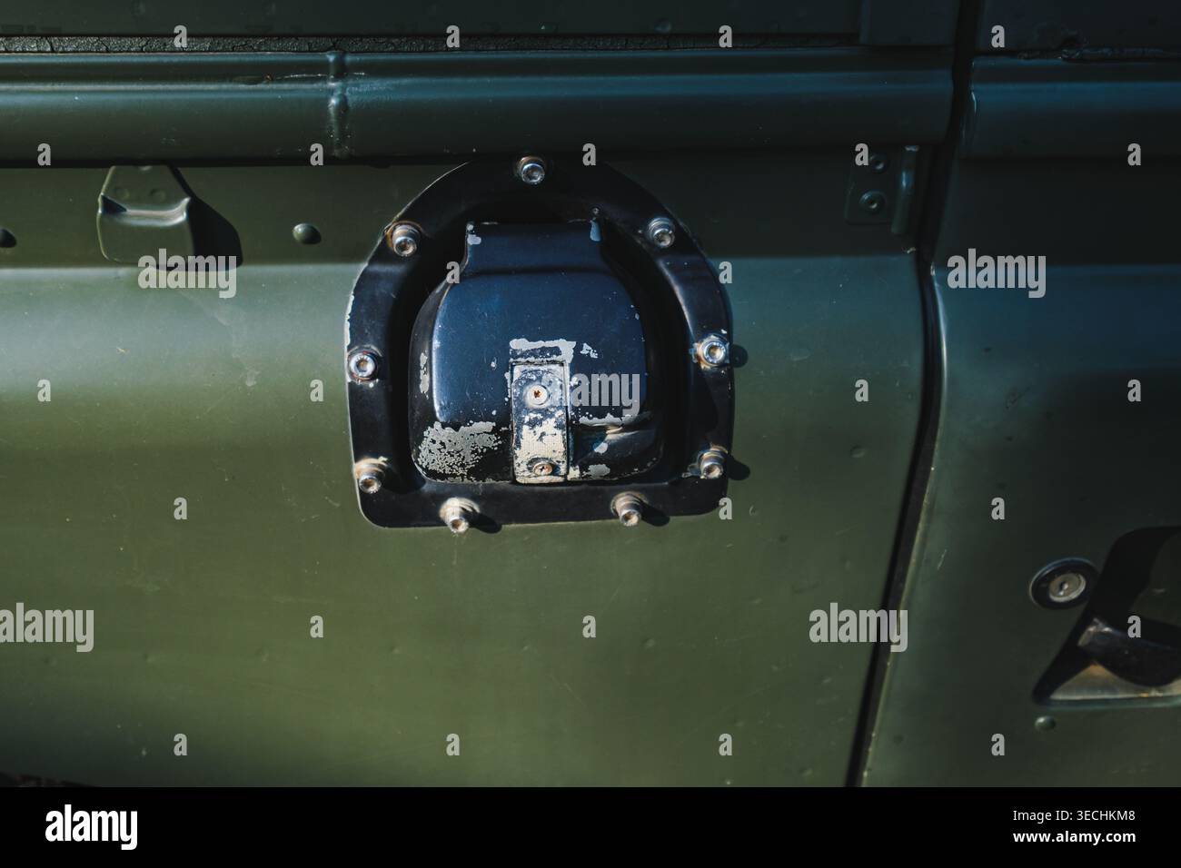 Eine detaillierte Nahaufnahme eines schwarzen Einfüllstutzens und eines Deckels an der Seite eines klassischen dunkelgrünen Nutzfahrzeugs. Stockfoto