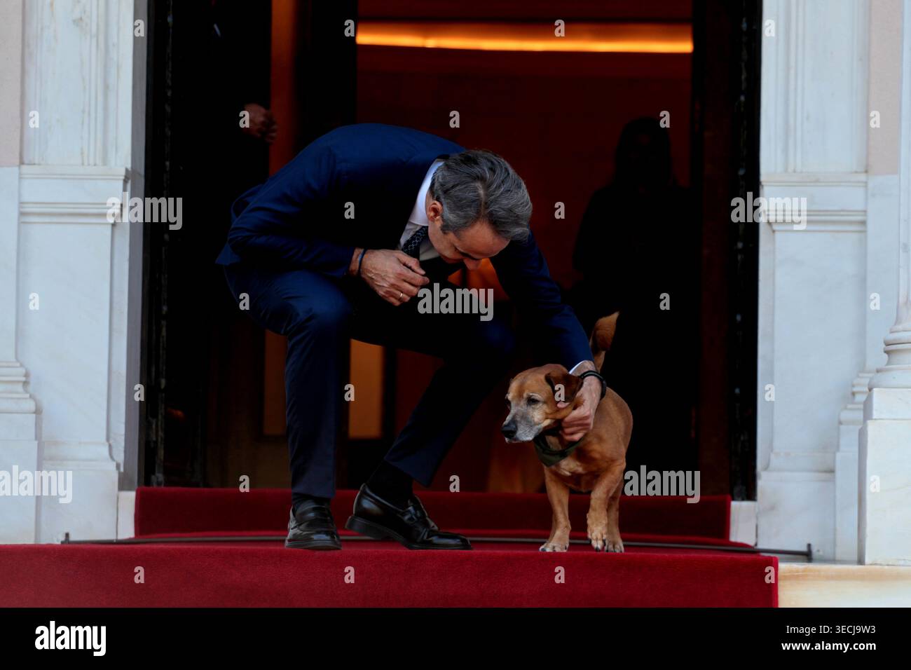 Griechenlands Premierminister Kyriakos Mitsotakis streichelt seinen Hund Peanut, bevor Monacos Fürst Albert II. Im Herrenhaus Maximos eintrifft Stockfoto