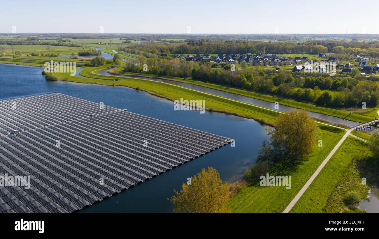 Aus der Vogelperspektive von Sekdoornse Plas mit einer großen Auswahl an schwimmenden Solarpaneelen umgeben von grünen Wiesen und Wohnhäusern in Zwolle, Overijss Stockfoto