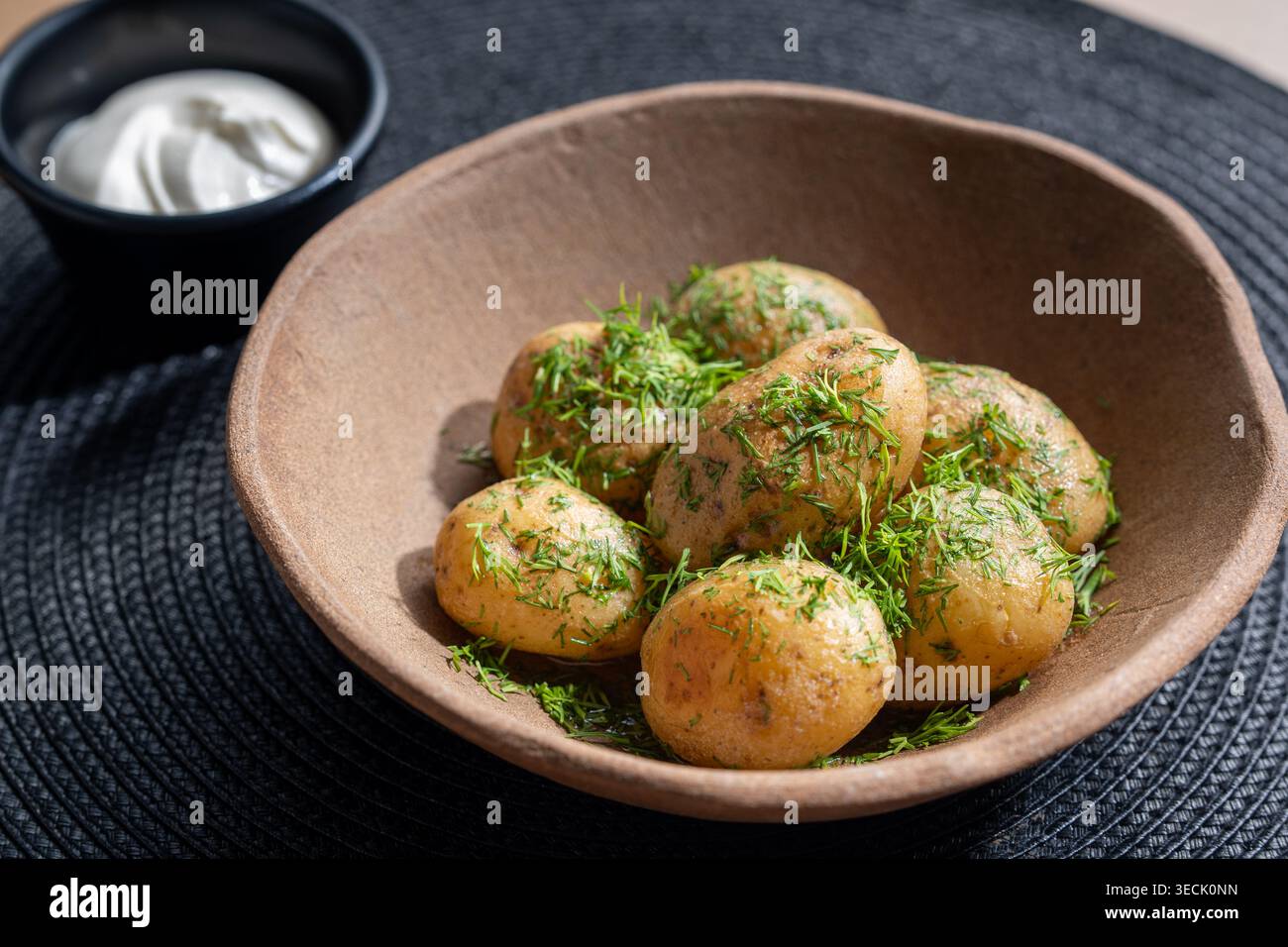 Rustikale Tonschale mit Babykartoffel mit Dill und Creme Dip Stockfoto