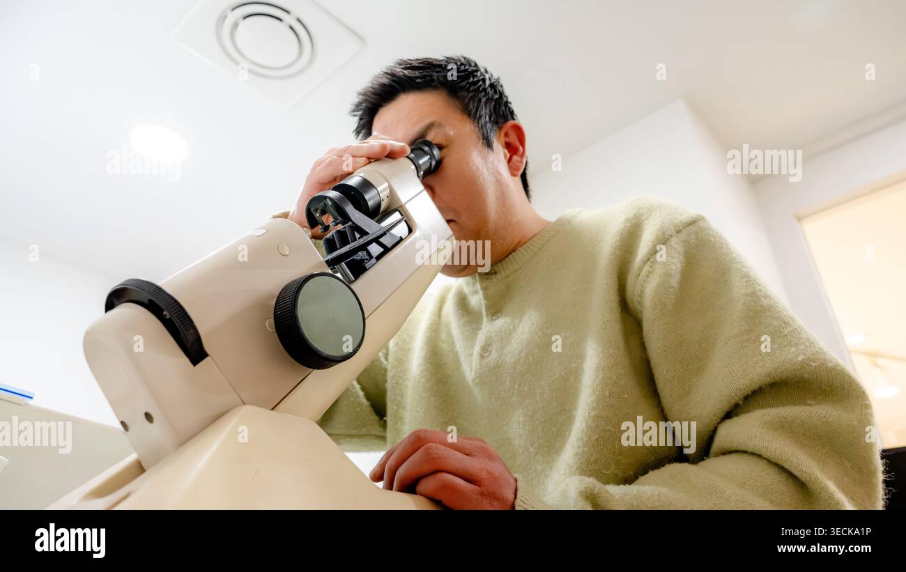 Ein professioneller Optikspezialist arbeitet mit Präzisionsinstrumenten in einem optischen Zentrum, um eine hohe Kundenzufriedenheit und akribische Augenpflege zu gewährleisten Stockfoto