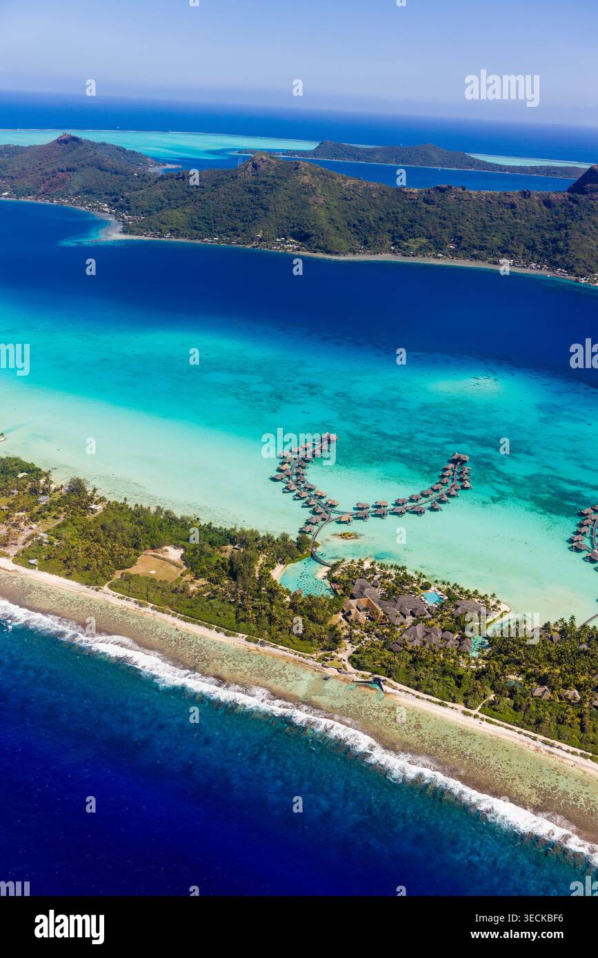 Luftpanorama von Bora Bora, Französisch-Polynesien, zeigt eine türkisfarbene Lagune, Korallenriff und Bungalows über dem Wasser entlang einer tropischen Inselküste unter Stockfoto