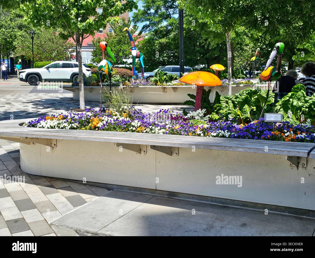 Skurrile Blumendekorationen in Pflanzgefäßen in Greenville, South Carolina. Bunte Tier- und Vogelskulpturen in einer urbanen Oase am SüdMain - Smartphone-aufgenommenes Stockfoto
