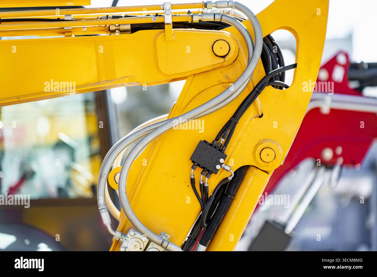 Mechanische Montage eines Bauschaufelarms mit Stahlgelenken und flexiblen Hydraulikleitungen, symbolisch für städtische Infrastrukturentwicklung und Heav Stockfoto