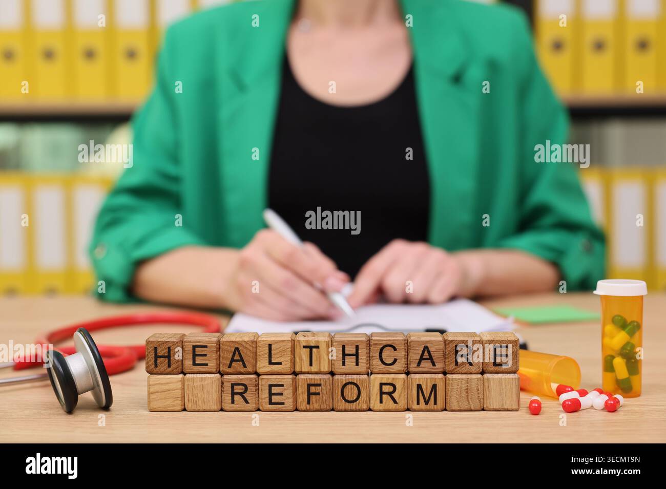 Diskussion über die Gesundheitsreform mit Holzklötzen und medizinischen Werkzeugen in einem gepflegten Büroumfeld Stockfoto