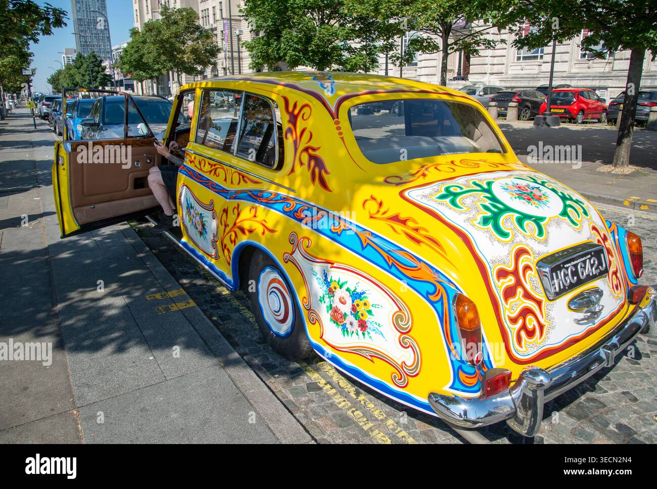 Liverpool, Merseyside, England, UK-10. August 2022: An einem Hochsommertag ist eine Kopie des berühmten gelben Beatles Car, dekoriert mit Hippie-Mustern der 1960er Jahre Stockfoto