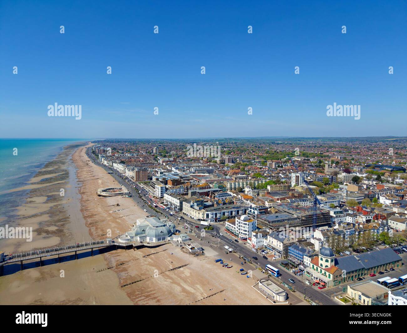 Aus der Vogelperspektive auf den Worthing Pier, die Küste und den Kiesstrand der Küstenstadt Worthing an einem sonnigen Frühlingstag in West Sussex, England, Großbritannien. Stockfoto