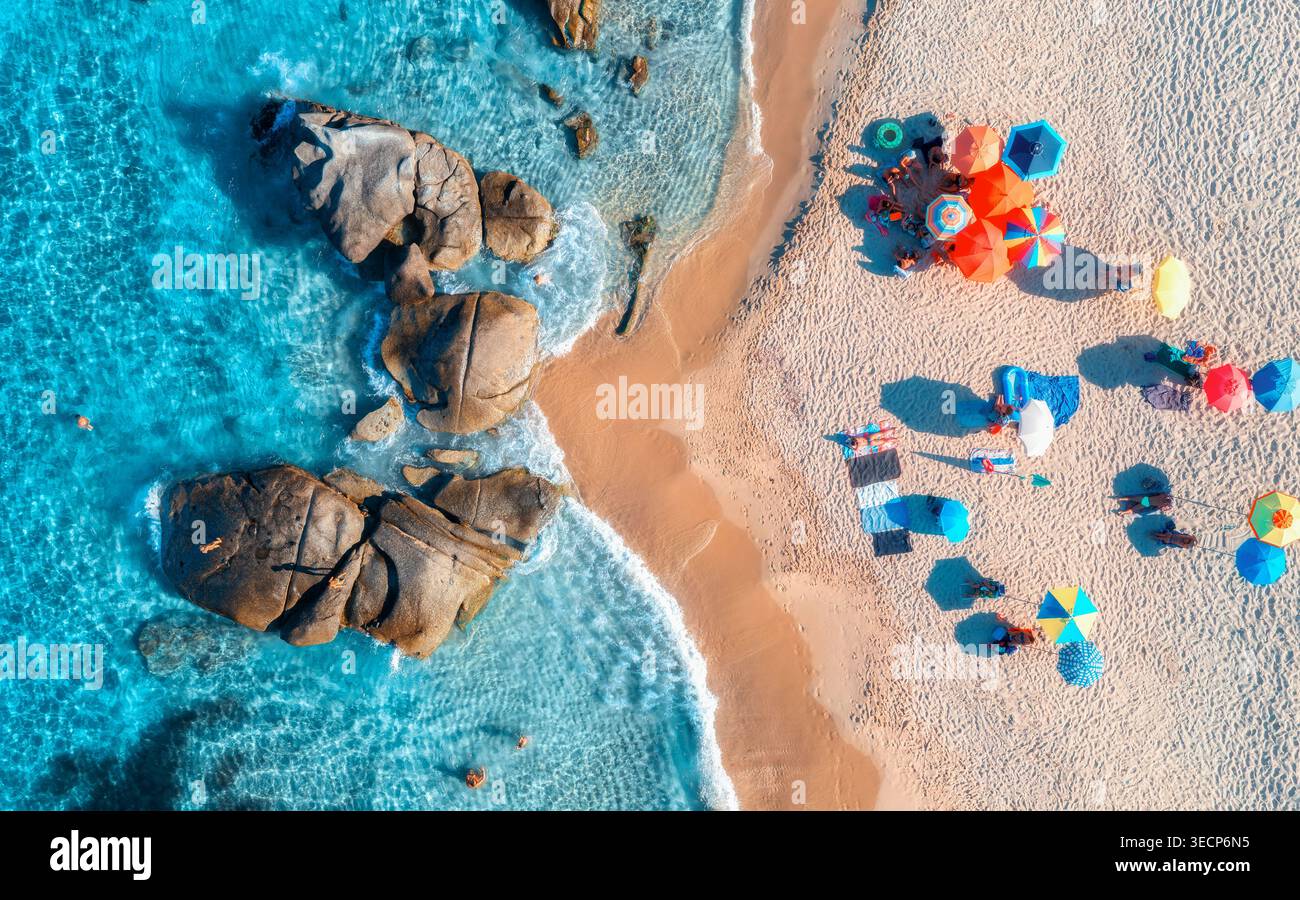 Blick von der Drohne auf bunte Sonnenschirme, Sandstrand und blaues Meer Stockfoto