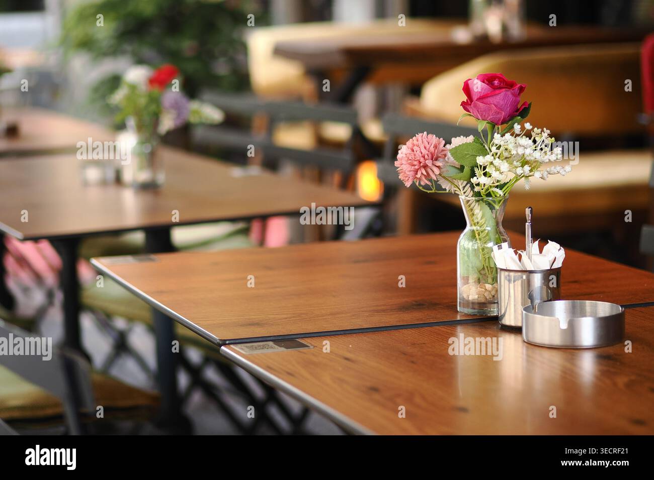 Blumenarrangements auf Tischen im Essbereich im Freien Stockfoto