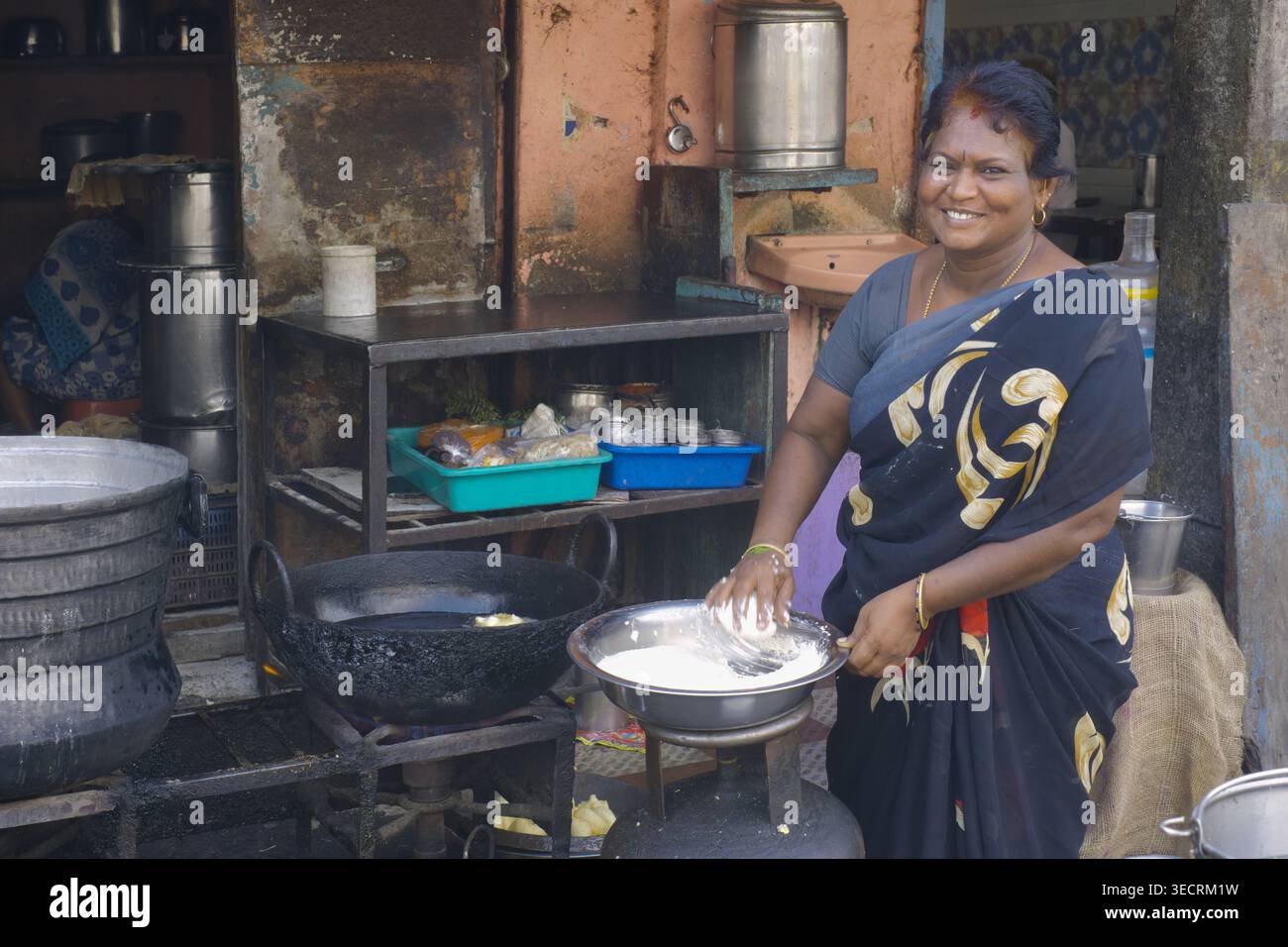 Eine Frau in Kanchipuram, Tamil Nadu, Südindien, die den Teig für das Grundnahrungsmittel Idli von S.Indian zubereitete, Reiskuchen mit Chutney und Sambhar Stockfoto
