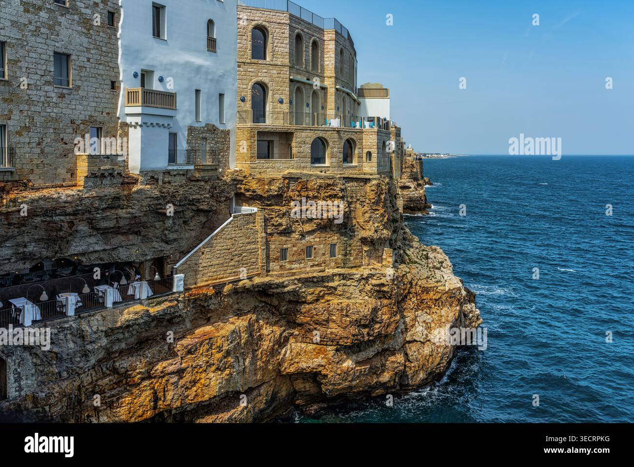 Polignano A Mare mit seinen historischen Gebäuden auf Klippen mit Blick auf das blaue Meer und einem eleganten Restaurant in einer Höhle. Polignano A Mare Stockfoto