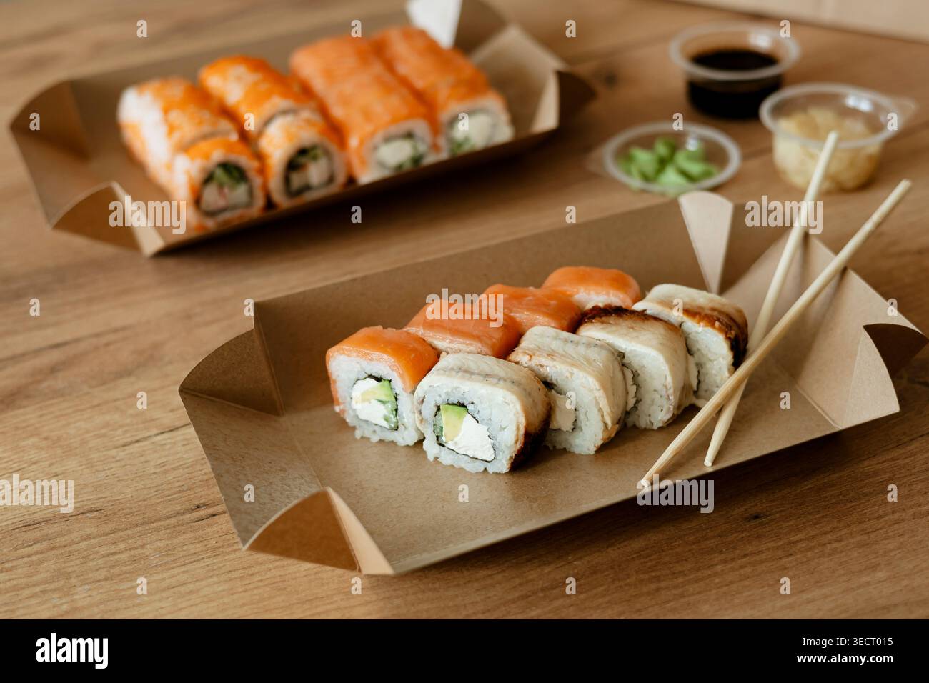 Ein entspannter Tag zu Hause mit köstlichem Sushi in umweltfreundlicher Verpackung, mit einer Vielzahl von frischen, bunten Brötchen, perfekt für einen Indu Stockfoto
