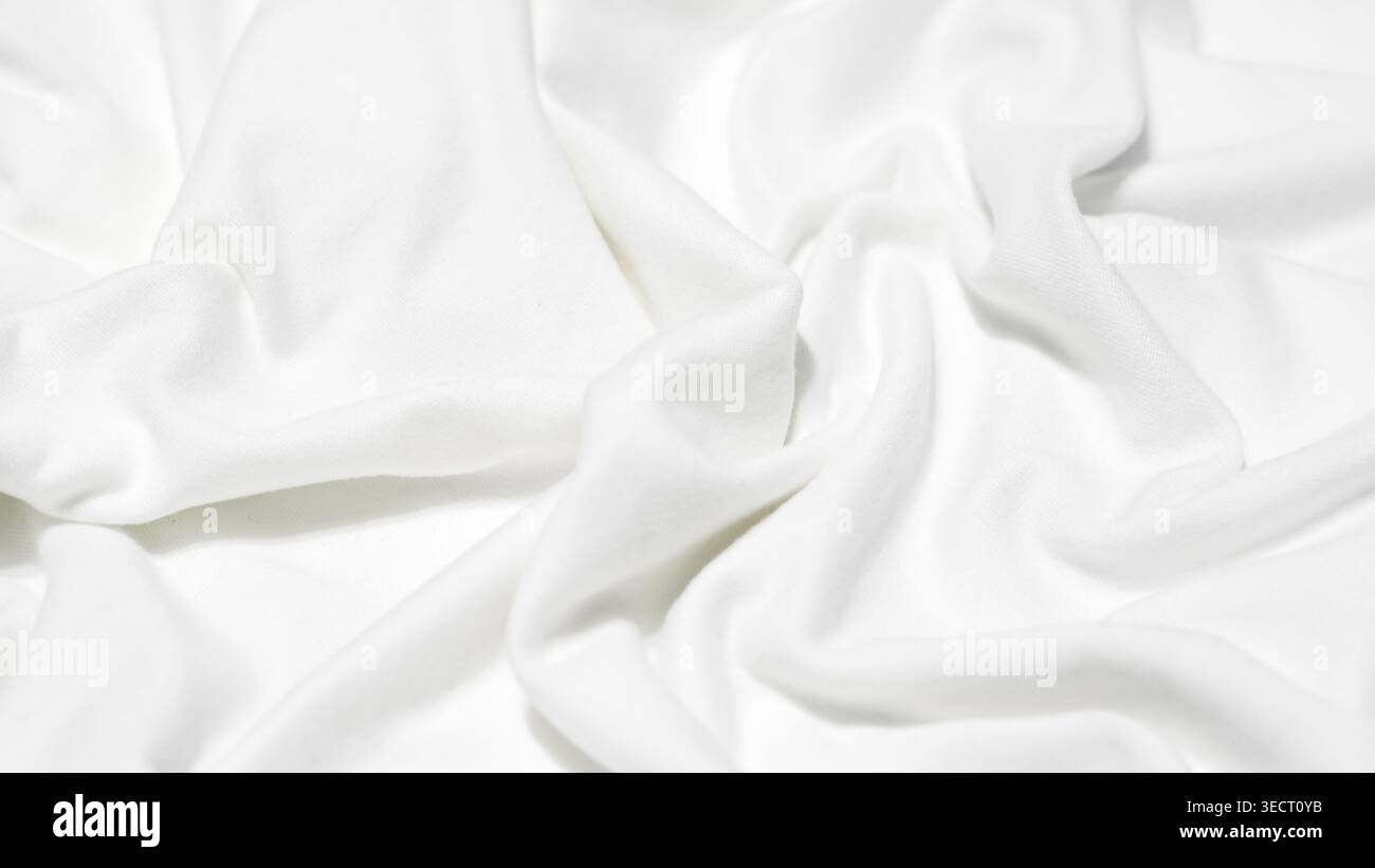 Detailansicht von weißem Stoff mit tiefen, unregelmäßigen Falten und einer weichen, matten Textur Stockfoto