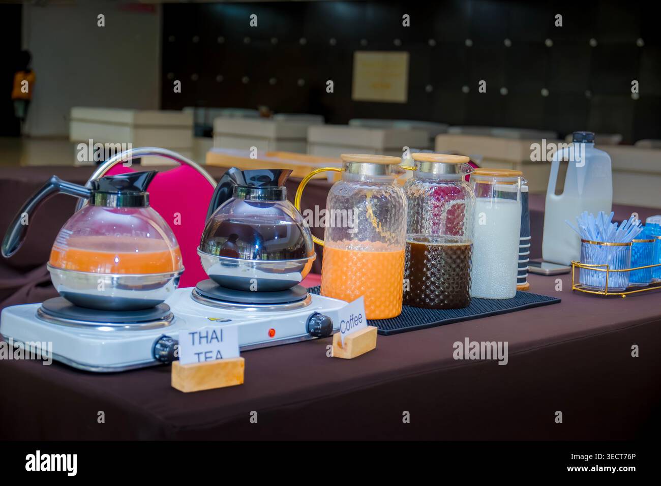 Hotel-Buffet-Selbstbedienungs-Getränkestation mit thailändischem Milchtee, Kaffeekaraffen und frischen Milchkannen auf dem Tisch. Stockfoto