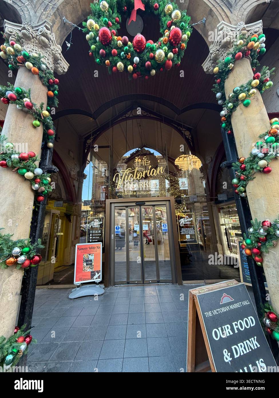 Ein detailliertes Außenfoto zeigt den kunstvollen Eingang zum Highlands Christmas Market in Schottland, Großbritannien, mit - Smartphone-aufgenommenes Stockfoto