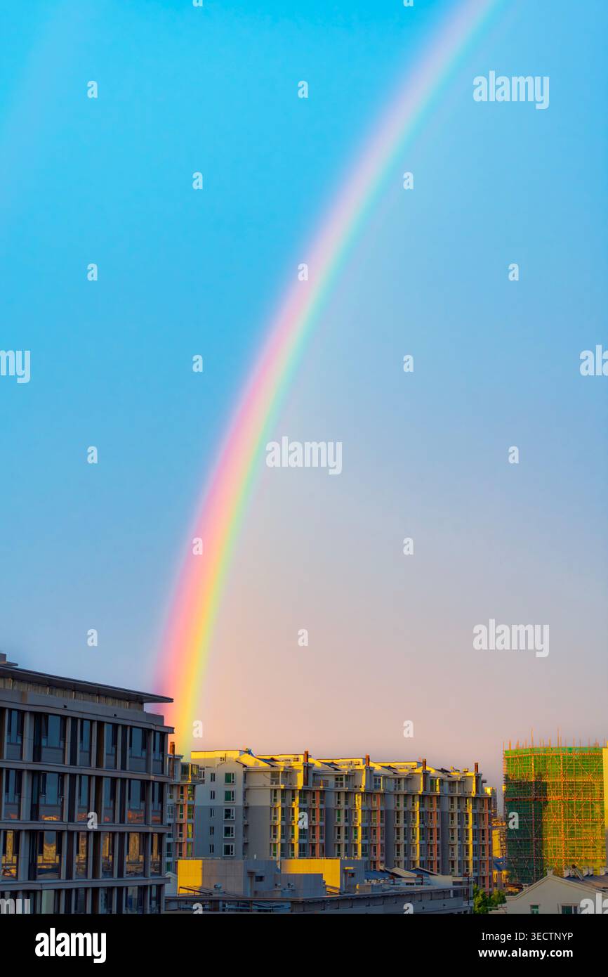 Peking, China - 02. Mai 2026: Pulsierender Regenbogen über Wohngebäuden und Baustellen während der goldenen Stunde Stockfoto