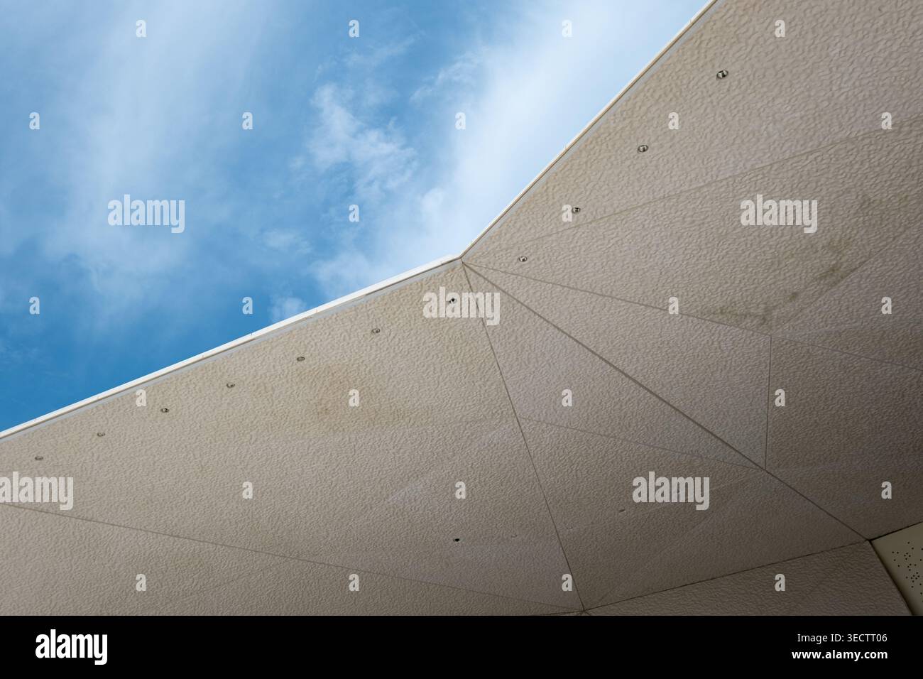 Abstrakte architektonische Oberfläche mit geometrischen Linien und blauem Himmel Hintergrund Stockfoto