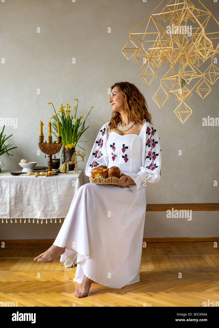Ukrainische Frau im traditionellen bestickten Kleid mit Osterbrot. Kulturelles Erbe, festliche Traditionen, Familienfest und saisonaler Urlaub Stockfoto