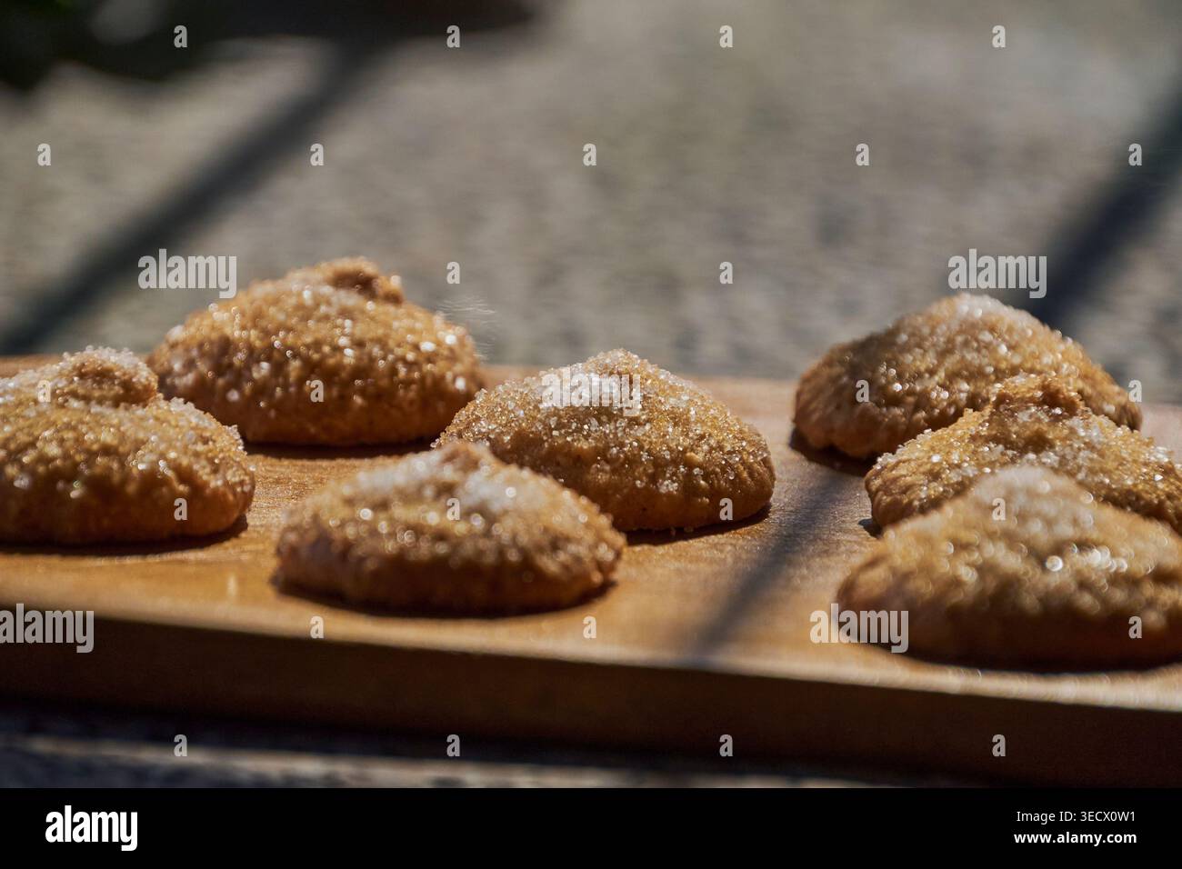 Braune Zuckerkekse auf einem Holzbrett mit Sonnenlicht, die Highlights schaffen Stockfoto