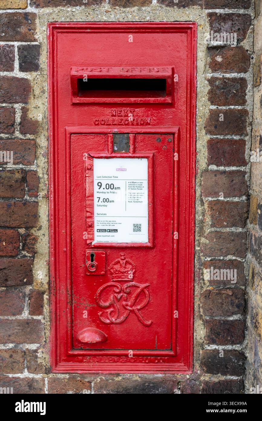 Ein roter Briefkasten der Royal Mail, der in einer Ziegelmauer aufgestellt ist. Stockfoto