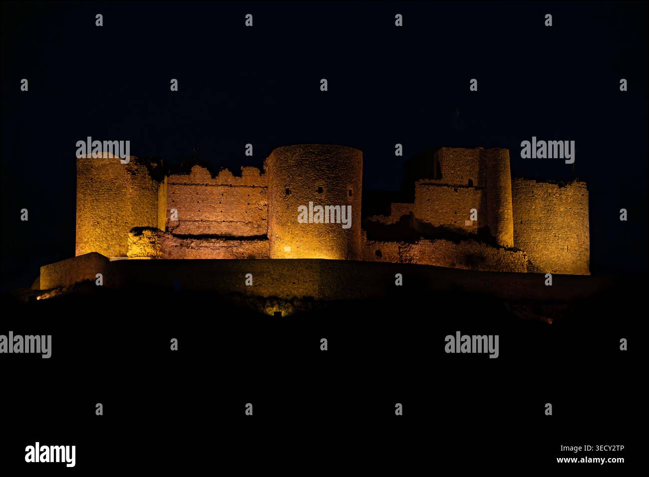 Blick auf den Sonnenuntergang von traditionellen Windmühlen in Consuegra, Spanien. Malerische Landschaft der historischen Windmühlen auf dem Hügel mit der Stadt in der Backgr Stockfoto