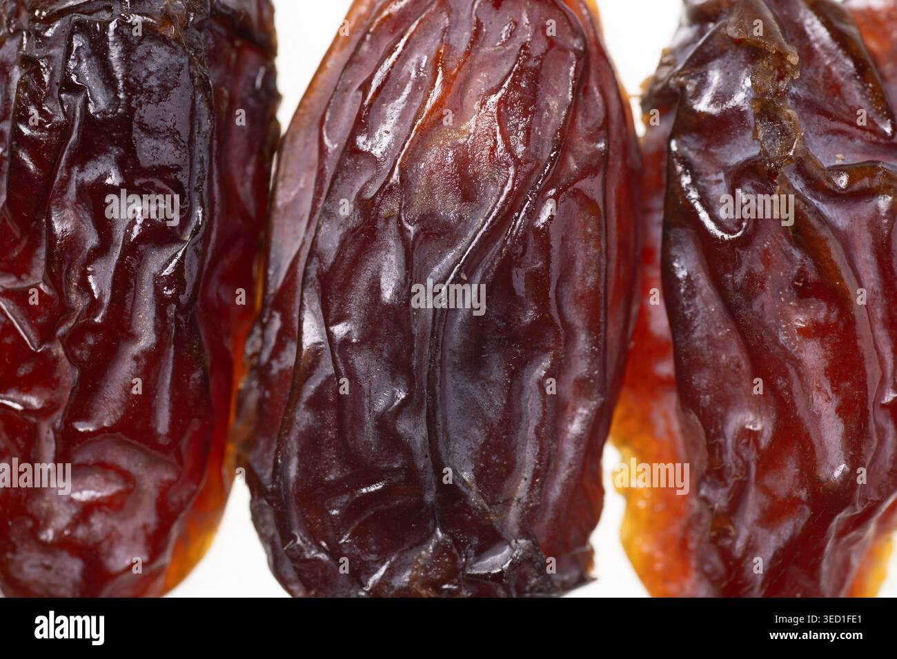 Drei getrocknete Datteln, die Textur und Farbe zeigen. Stockfoto
