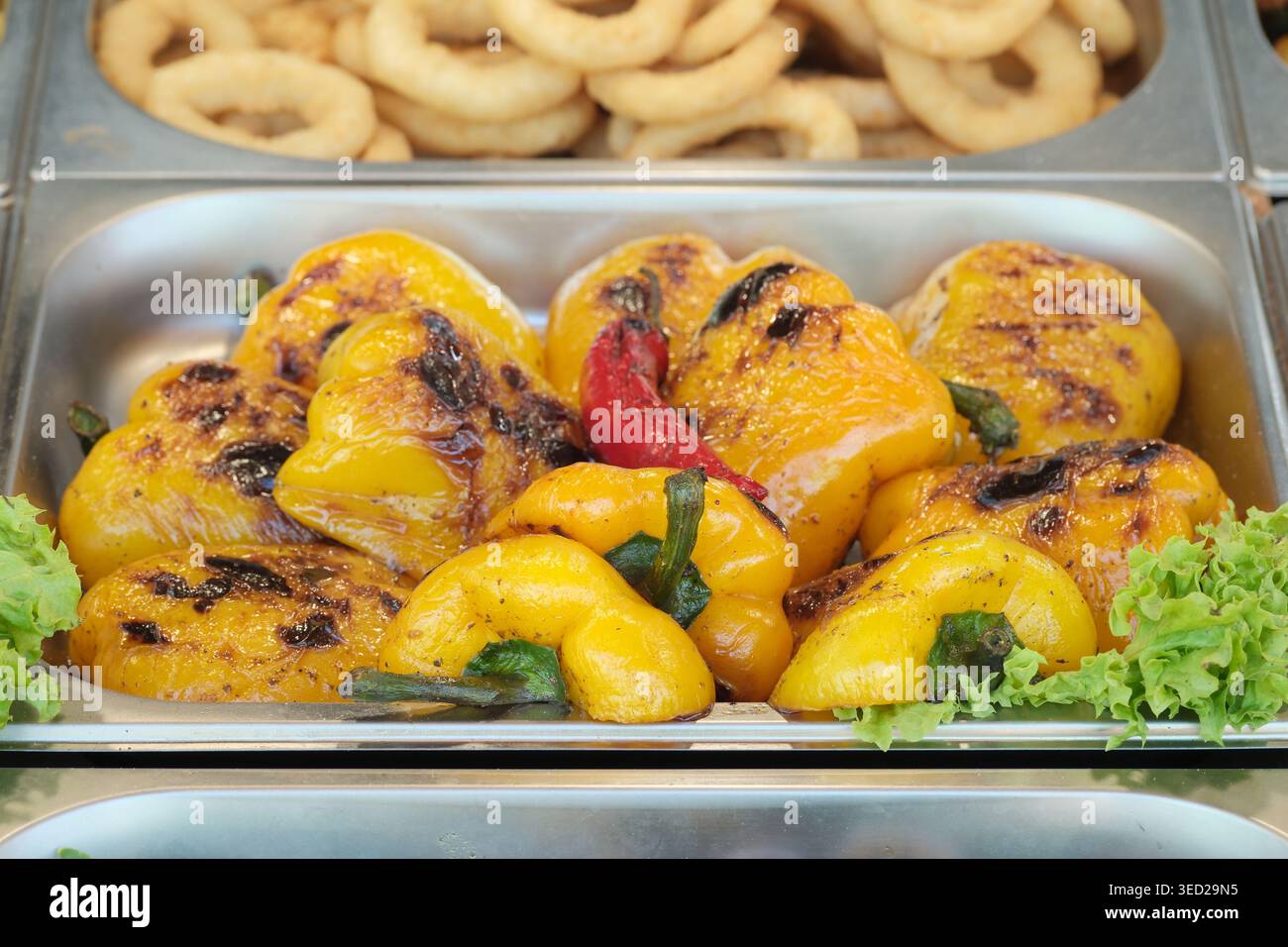Gegrillte, hellgelbe Paprika mit frischem Grün sorgen für kulinarische Köstlichkeiten. Stockfoto