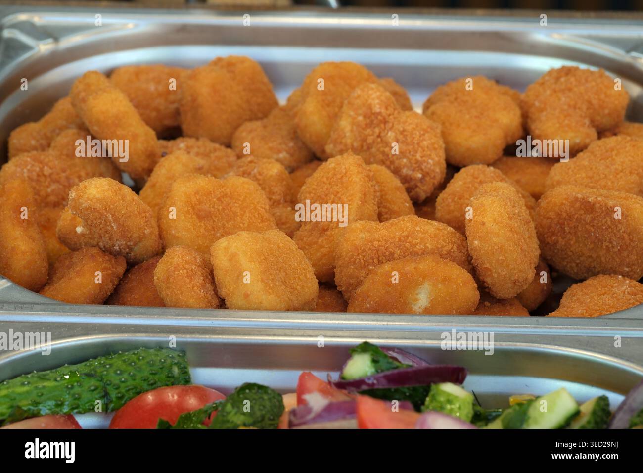 Ein köstlicher Aufstrich goldener Chicken Nuggets, die Sie mit frischem Gemüse genießen können. Stockfoto