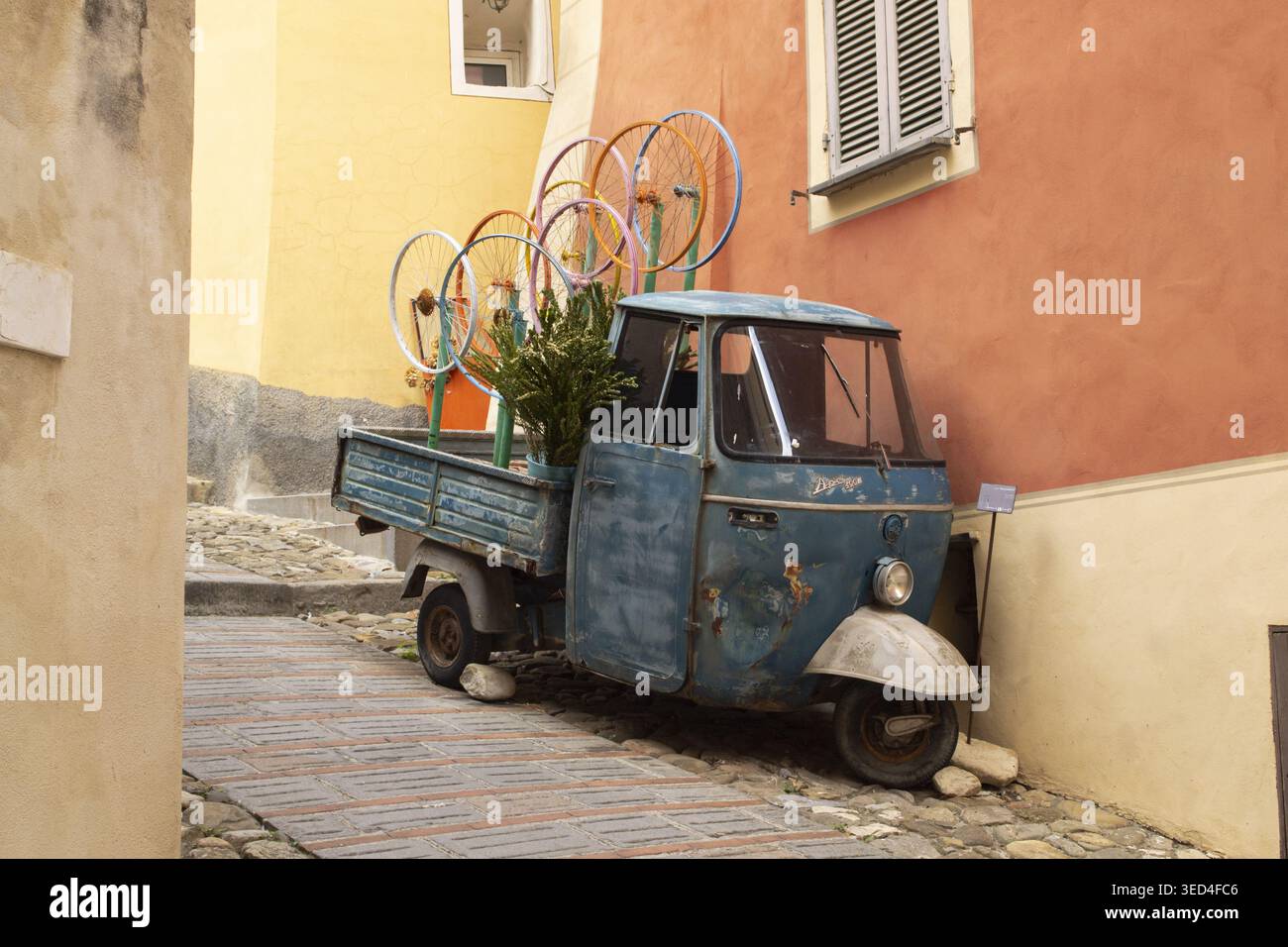 Piaggio Ape malerisches Retro-Auto in einer kleinen Steinstadt in den Bergen dekoriert Stockfoto