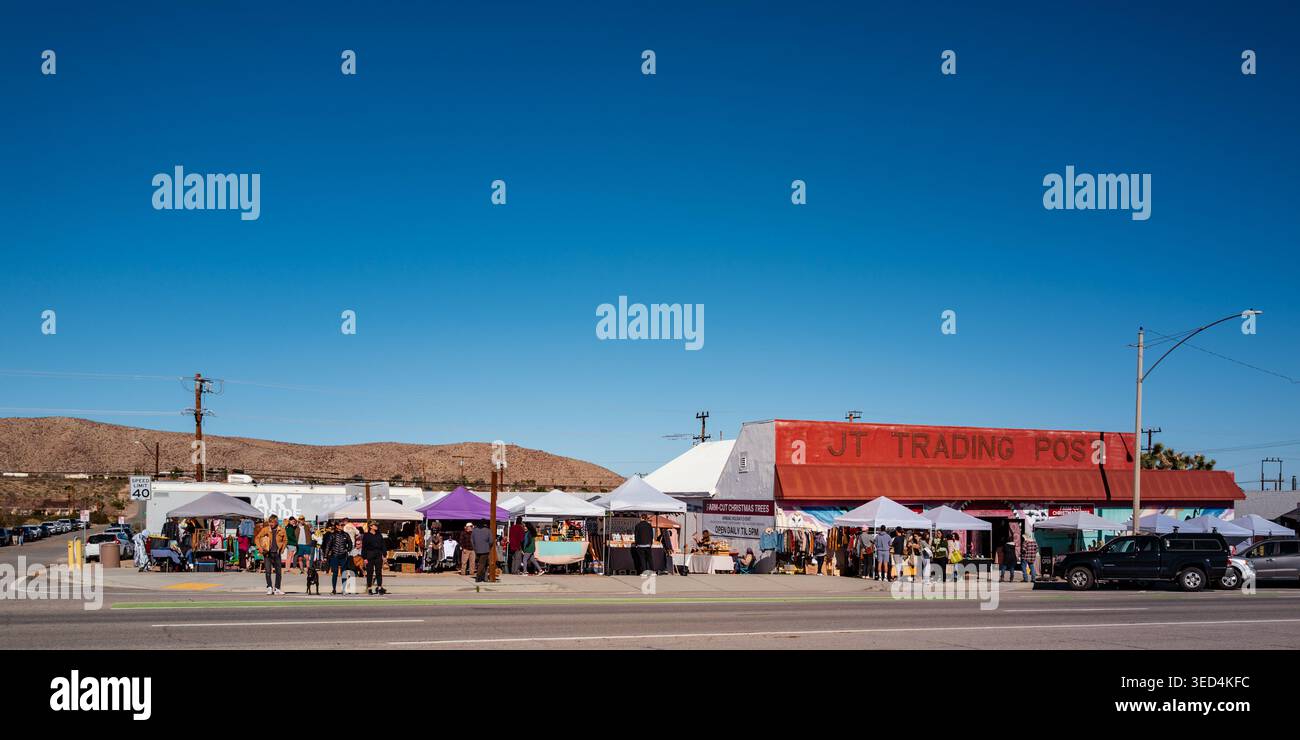 Freiluftmarkt mit Verkaufsständen und Besuchern vor dem Joshua Tree Trading Post in Joshua Tree, Kalifornien, unter einem klaren blauen Himmel. Stockfoto