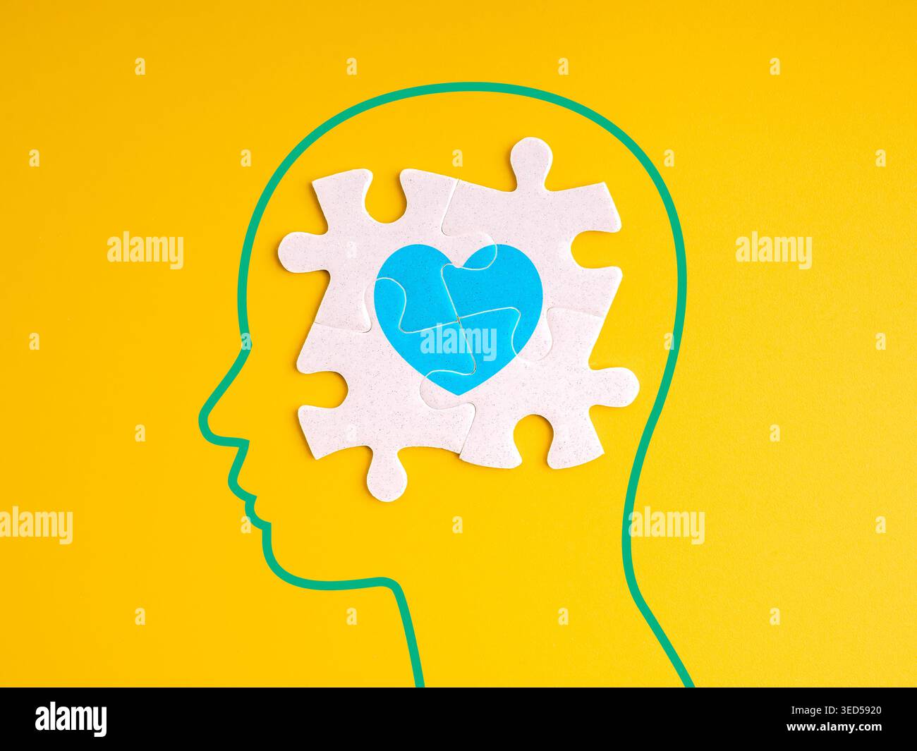 Emotionale Intelligenz-Konzept mit menschlicher Kopfsilhouette und Rätselherz auf. Gelb. Psychische Gesundheit, emotionales Gleichgewicht, Selbstbewusstsein, Psychologie, ich Stockfoto