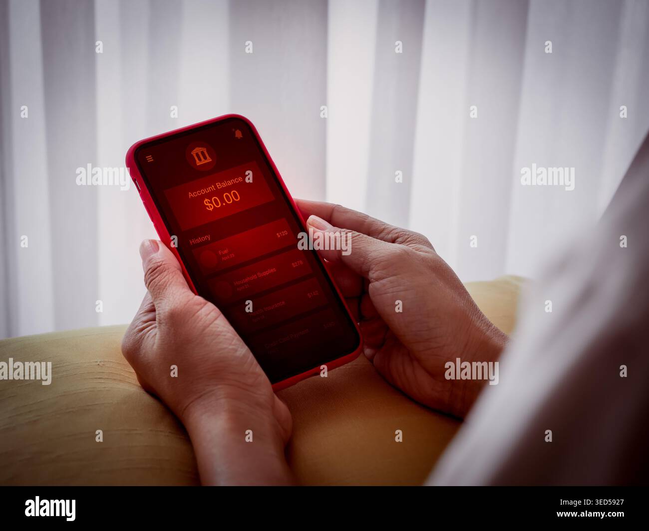 Person, die ein niedriges, leeres Bankkonto in der mobilen Banking-App mit rotem Warnbildschirm überprüft. Finanzkrise, Geldknappheit, persönliche Finanzen Stockfoto