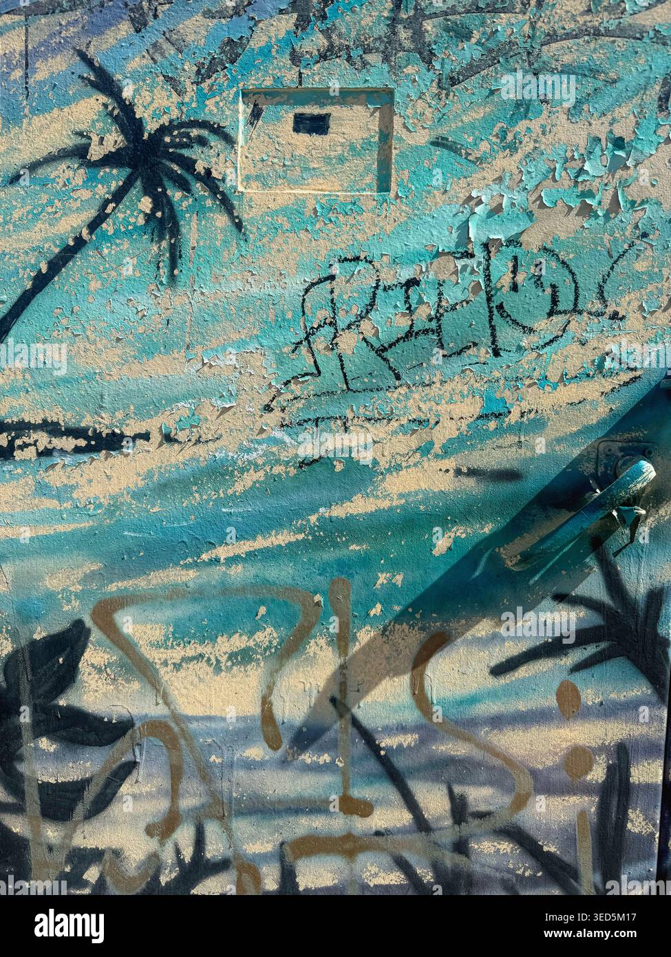 Graffiti-Wand am Strand mit Meerblick und tropischer Landschaftstafel verwittert - Smartphone-aufgenommenes Stockfoto