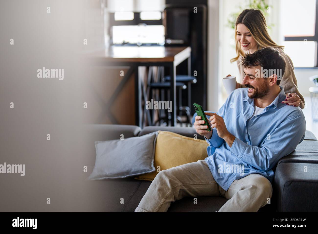 Glückliches Paar, das sich zu Hause bei einem Kaffee entspannt, Online-Shopping genießt und digitale Erlebnisse teilt Stockfoto