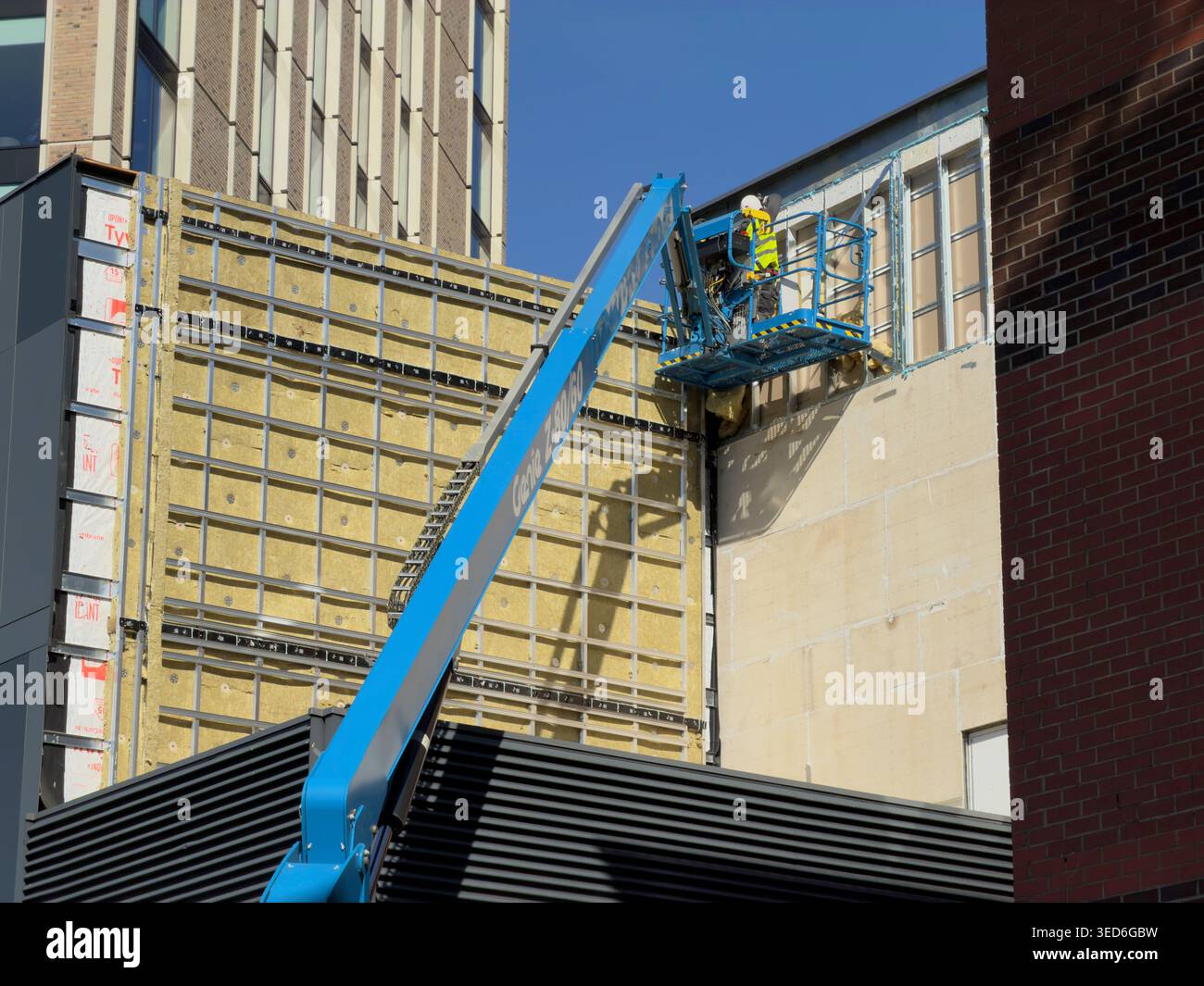 Leicester, Großbritannien - 13. März 2026: Bauarbeiter auf Kirschpflücker reparieren isolierte Gebäudefassade, Leicester Stockfoto