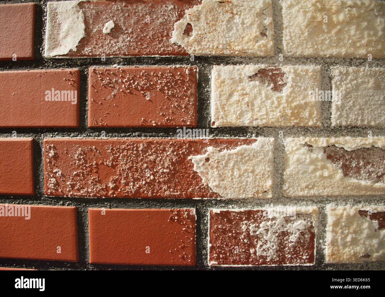 Nahaufnahme der roten Ziegelwand mit weißen Putz- und Mörteldetails. Rustikaler Mauerwerkhintergrund mit rauer Oberfläche, ideal für Tapeten, Hintergrund. Stockfoto