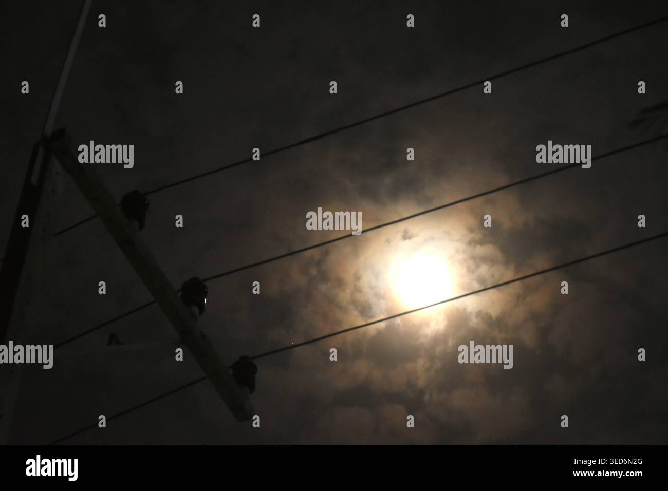 Elektromast und Kabel mit Vollmond auf Wolke in der Nacht Stockfoto